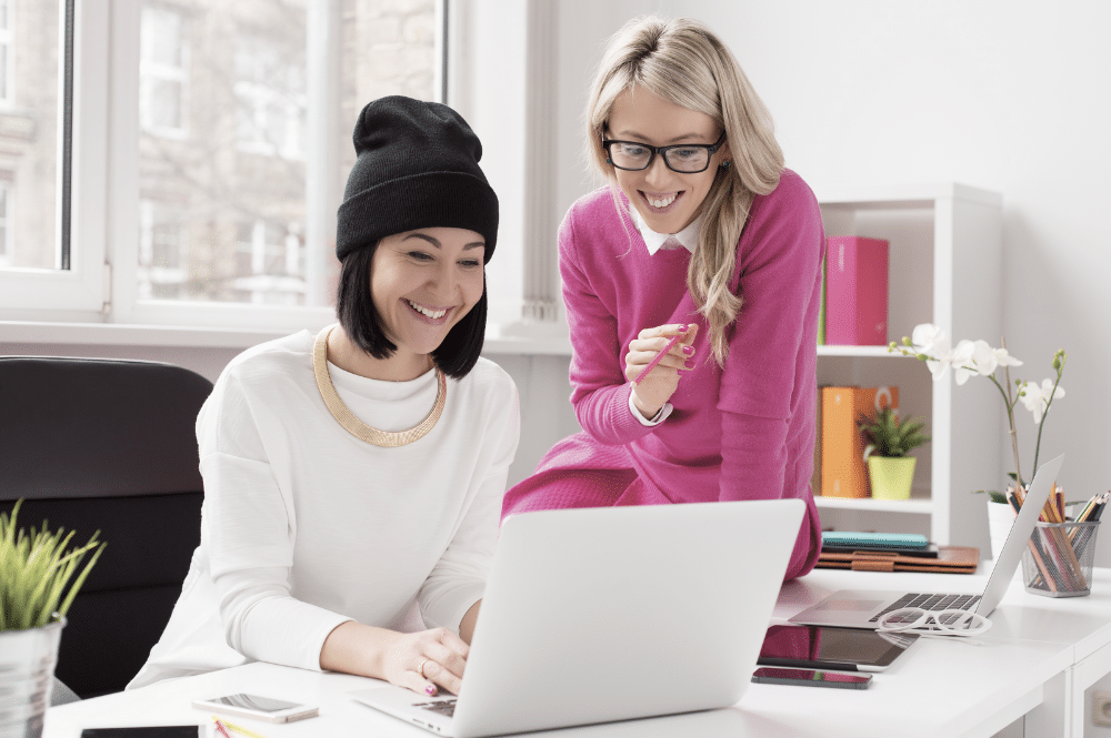 two people working on a laptop in an office